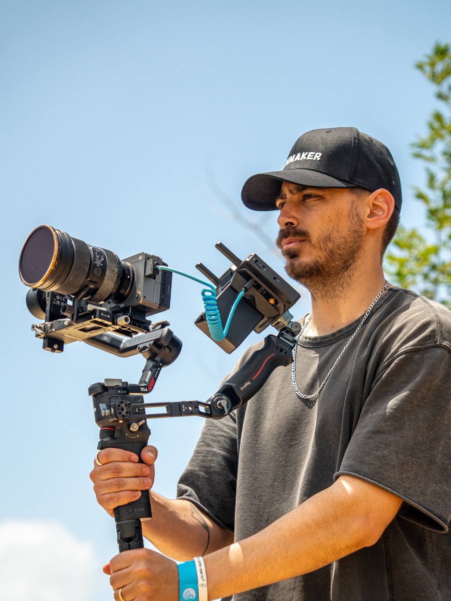 Yuval operating a gimbal rig against a blue sky